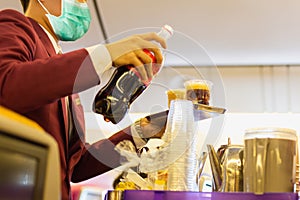 Flight attendant in facial mask protection from covid-19 serves passengers a drink.