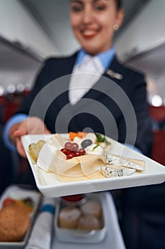 Flight attendant handing out plate with breakfast