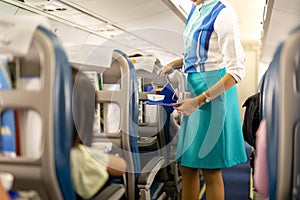 Flight attendant serving drinks to passengers on board. photo