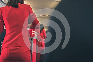 flight attendant serving food to passenger on aircraft. stewardess offer drink on board. hostess with trolley