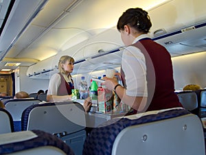 Flight attendants serving food to passengers during flight