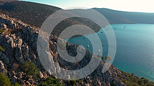 Flight from behind a crest of a cliff overlooking the bay. Dokos Island, Greece.