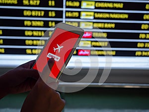 Flight check-in by mobile phone. Hand touching on smartphone screen to check-in for a flight