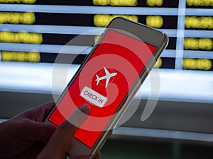Flight check-in by mobile phone. Hand touching on smartphone screen to check-in for a flight