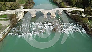 Flight counterclockwise over the river with rapids and the ancient roman bridge