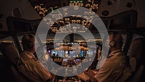 Flight Deck of a modern commercial jet transport aircraft during night cruise. Cozy airliner cockpit atmosphere generated by warm