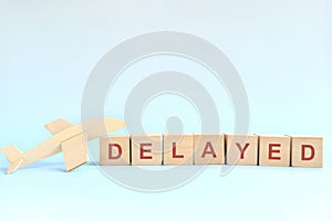 Flight delay concept. Wooden blocks typography on blue background. photo