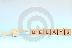 Flight delay concept. Wooden blocks typography on blue background. photo