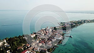 Flight by a drone, aerial view of Rocca Scaligero Castle in Sirmione. Lake Garda. Italy.