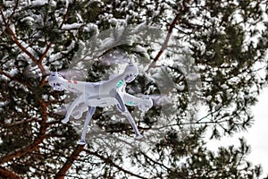 Flight of the drone in the winter forest. The concept of unmanned aircrafts Quadcopter, technology and surveillance