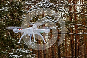 Flight of the drone in the winter forest. The concept of unmanned aircrafts Quadcopter, technology and surveillance