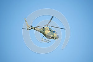 Flight of the military helicopter in the sky at sunny day