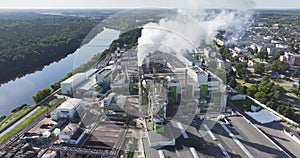 flight near pipes with white smoke of woodworking enterprise plant