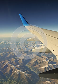 Plane wing over mountains