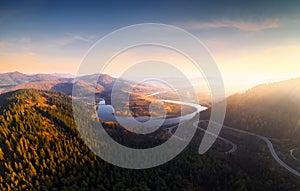 Flight over the autumn mountains with mountain road serpentine