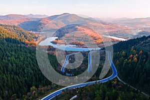 Flight over the autumn mountains with mountain road serpentine