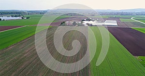 Flight over beautiful agricultural fields. Agrarian fields and greenhouses aerial view. Flight over green agricultural