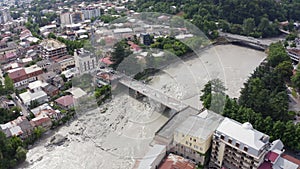 Flight over the city of Kutaisi, Georgia. Bagrati`s Cathedral and River Rioni and old houses with Red roofs. Mountains in the dist