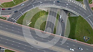 Flight over city roads. Above a multilevel road junction, the camera is lowered down. Below you can see the movement of public