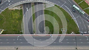 Flight over city roads. Above a multilevel road junction, the camera is lowered down. Below you can see the movement of public