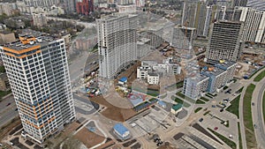 Flight over the construction site. High-rise buildings under construction and construction cranes are visible. Aerial photography