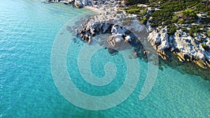 Flight over the exotic turquoise sea with massive rocks on the coast. Aerial view