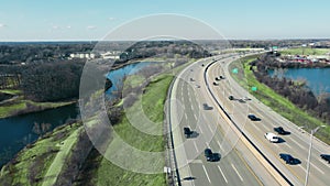 Flight over the highway and car traffic moving in the direction of the big city. Large highway with heavy traffic.