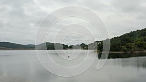 Flight over a large lake with a man kayaking over the lake