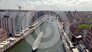 Flight over Motlawa river in old town of Gdansk at sunny. View of the MotÅ‚awa River with a closed footbridge