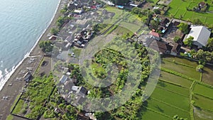 Flight over of Pantai Amed beach. Aerial view of beach - Bali, Indonesia. Scenic aerial fly over black volcanic sand