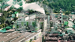 flight over pipes with white smoke of woodworking enterprise plant sawmill. Air pollution concept on industrial landscape