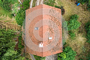 Flight over the red roof of a single family house with a chimney and a satellite antenna for inspection, control and preparation f