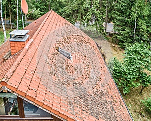 Flight over the red roof of a single family house with a chimney and a satellite antenna for inspection, control and preparation f