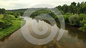 Flight over the river in the middle of green forest. Shallow area. Aerial motion