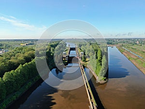 Flight over the river. Passage of hydraulic locks on the channel by commercial cargo ship