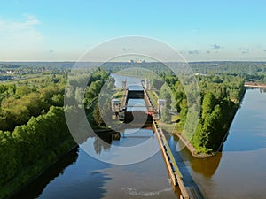 Flight over the river. Passage of hydraulic locks on the channel by commercial cargo ship