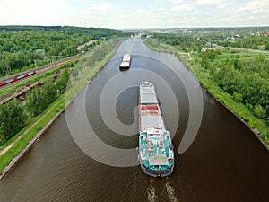 Flight over the river. Passage of hydraulic locks on the channel by commercial cargo ship