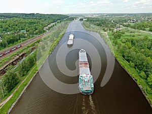 Flight over the river. Passage of hydraulic locks on the channel by commercial cargo ship