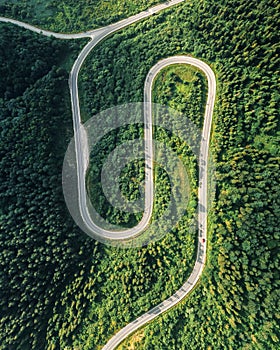 Flight over the summer mountains with mountain road serpentine