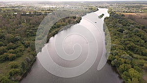 Flight over a wide river with green banks.