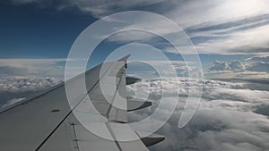 Flight of the plane on a flight level, against the background of blue sky and textural volumetric clouds. The view from