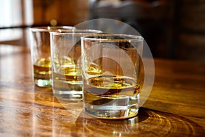 Flight of Scottish whisky, tasting glasses with variety of single malts or blended whiskey spirits on distillery tour in pub in