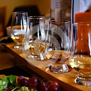 Flight of Scottish whisky, tasting glasses with variety of single malts or blended whiskey spirits on distillery tour in Scotland