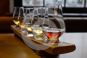 Flight of Scottish whisky, tasting glasses with variety of single malts or blended whiskey spirits on distillery tour in Scotland photo