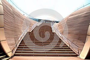 A flight of wooden stairs flanked by high wooden walls