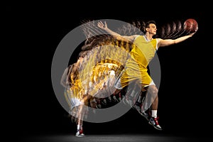 Flight. Young caucasian basketball player in motion and action isolated on dark background with stroboscope effect