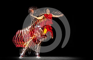 Flight. Young caucasian basketball player in motion and action isolated on dark background with stroboscope effect