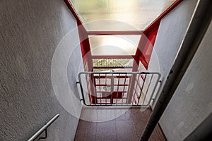 Flights of old stairs with brown wooden railings and steps and dark cream