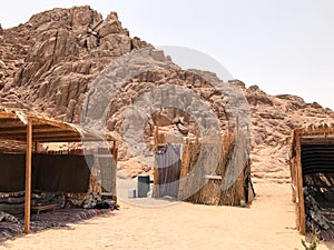 A flimsy, dilapidated decrepit, fragile, fragile poor dwelling, a Bedouin building made of straw, twigs in a sandy hot desert in t