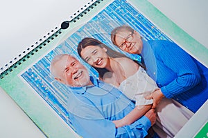 a flip calendar with family photos. grandparents with teenage granddaughters